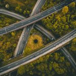 Aerial view of intersecting roads surrounded by trees.